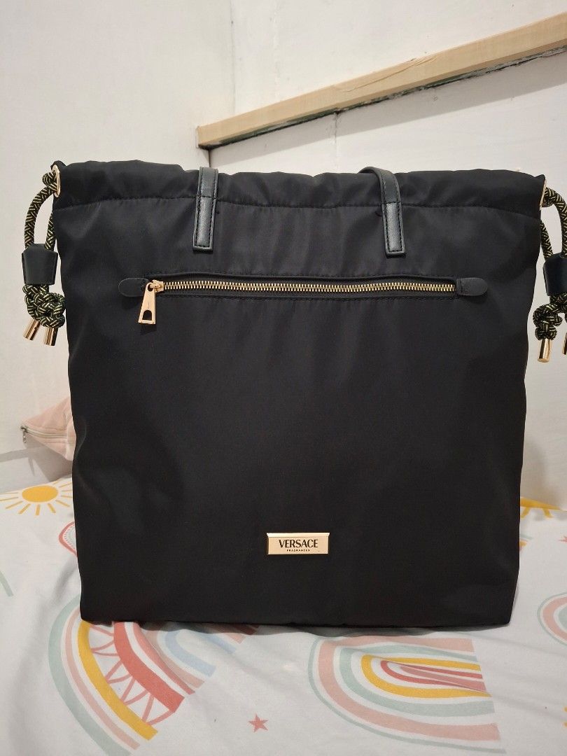 Versace Black Nylon Tote Bag (Category: Luxury Bags & Wallets) located in Las Pinas. Submitted by tn.gl (Listing ID 1452675013, Image 1). Description: - Black nylon tote bag from Versace Fragrances -Can Fit 14in. laptop - Elegant gold hardware details - Interior features Versace logo lining - Includes a convenient small pocket - Ideal for everyday use or travel used 3x only + free sf for sure buyer within metro manila.