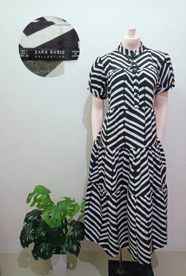 Zara Basic Collection Black & White Zigzag Midi Dress Size L (Category: Dresses) located in Angeles City. Submitted by leichen57360 (Listing ID 1452533758, Image 1). Description: - Zara Basic Collection midi dress - Size: L - Bold black and white zigzag pattern - Short puff sleeves - High neckline with button details - Tiered skirt with convenient pockets - Versatile for casual outings or making a statement.