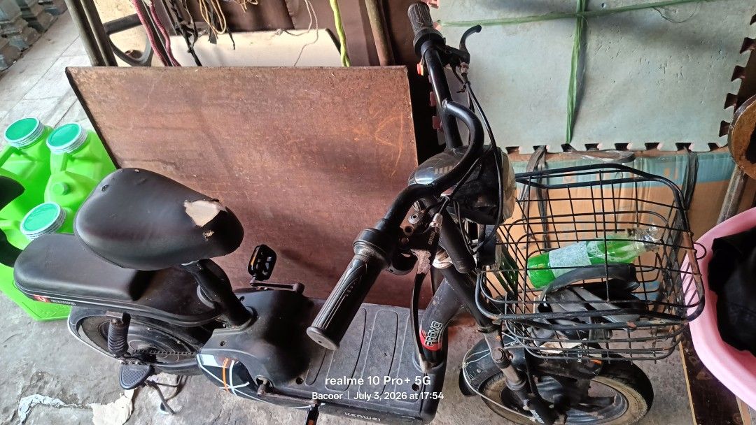 Black Electric Bicycle with Basket (Category: Bicycles) located in Bacoor. Submitted by missyoujohnie16292009.gokgok (Listing ID 1447386397, Image 1). Description: - Black electric bicycle - Includes a front basket for storage - Pedals are visible - Black seat with some signs of wear - Ideal for short neighborhood trips - Ready for its next owner.