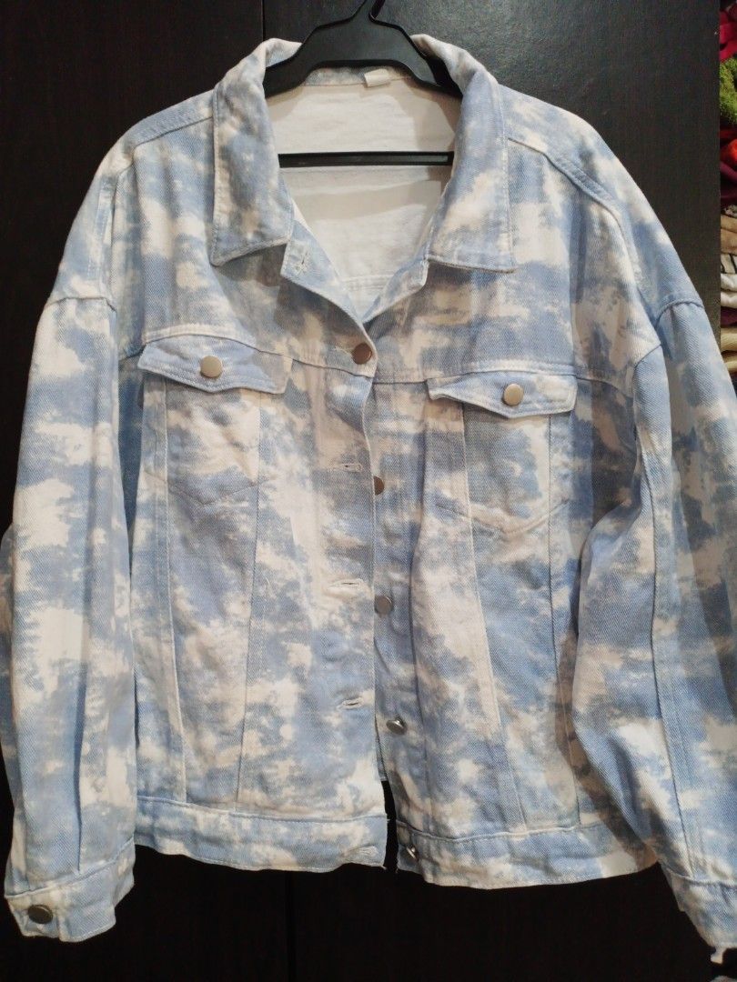 Blue and White Tie-Dye Denim Jacket (Category: Coats, Jackets and Outerwear) located in Manila. Submitted by ggarage.sale (Listing ID 1447373456, Image 2). Description: - Unique tie-dye denim jacket - Blue and white cloud pattern - Button-up front with two chest pockets - Relaxed fit for comfortable layering - Ideal for casual outings.