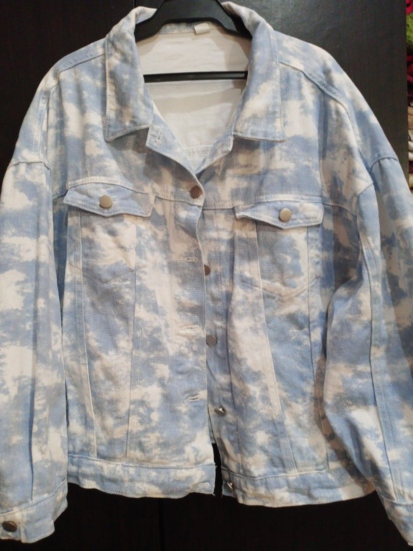 Blue and White Tie-Dye Denim Jacket (Category: Coats, Jackets and Outerwear) located in Manila. Submitted by ggarage.sale (Listing ID 1447373456, Image 3). Description: - Unique tie-dye denim jacket - Blue and white cloud pattern - Button-up front with two chest pockets - Relaxed fit for comfortable layering - Ideal for casual outings.