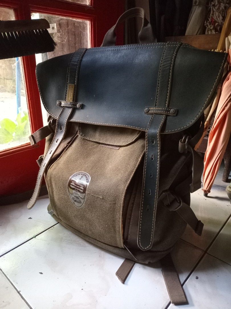 National Geographic Camera Backpack (Category: Backpacks) located in Cagayan de Oro. Submitted by joven.uy86-31596 (Listing ID 1447315153, Image 1). Description: - Olive green canvas backpack - Dark blue leather accents - Wide-opening main compartment - Interior orange lining with mesh pockets - Padded shoulder straps for comfort - Secure buckle closures on front flap - Ideal for everyday use or travel.