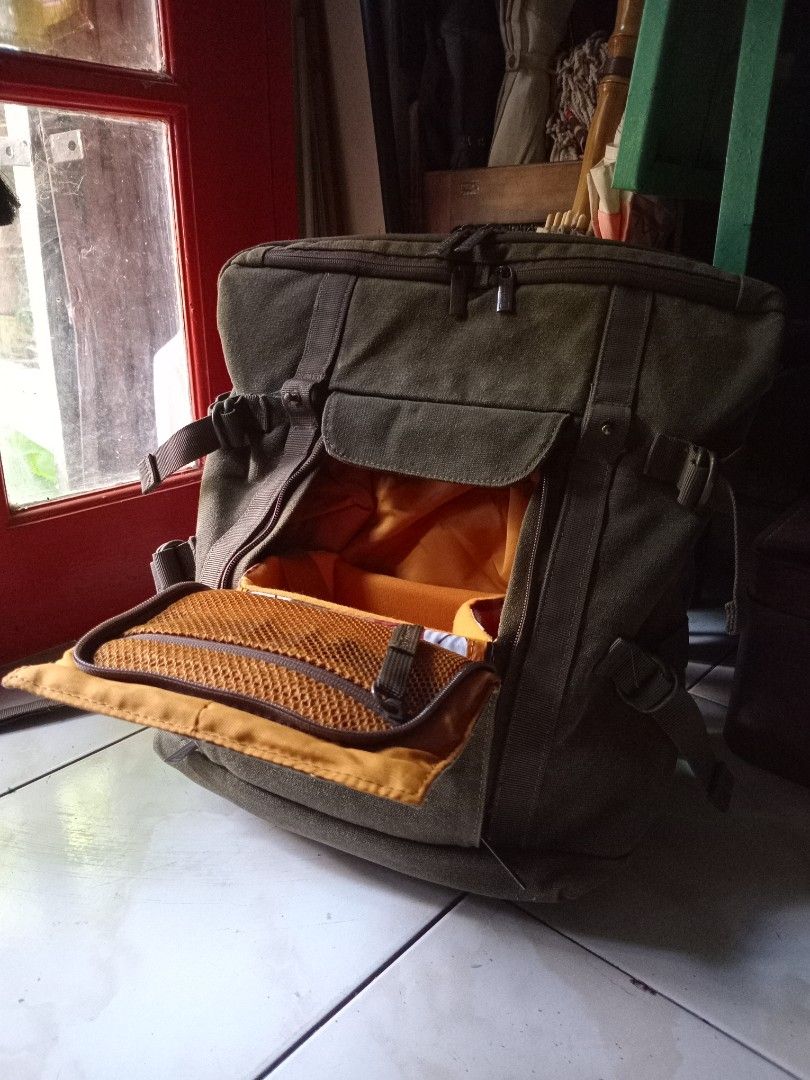 National Geographic Camera Backpack (Category: Backpacks) located in Cagayan de Oro. Submitted by joven.uy86-31596 (Listing ID 1447315153, Image 2). Description: - Olive green canvas backpack - Dark blue leather accents - Wide-opening main compartment - Interior orange lining with mesh pockets - Padded shoulder straps for comfort - Secure buckle closures on front flap - Ideal for everyday use or travel.