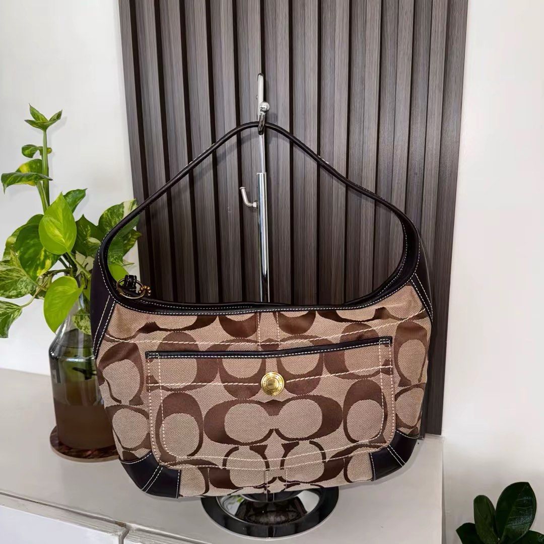 Coach Ergo (Category: Luxury Bags & Wallets) located in Los Banos. Submitted by vvvintiquecollectives (Listing ID 1447327177, Image 1). Description: - Classic Coach hobo bag - Signature monogram canvas with dark brown leather trim - Front pocket with gold-tone clasp - Top zipper closure - Timeless design for everyday use - Comes with Coach hang tag - Negotiable for sure buyers .
