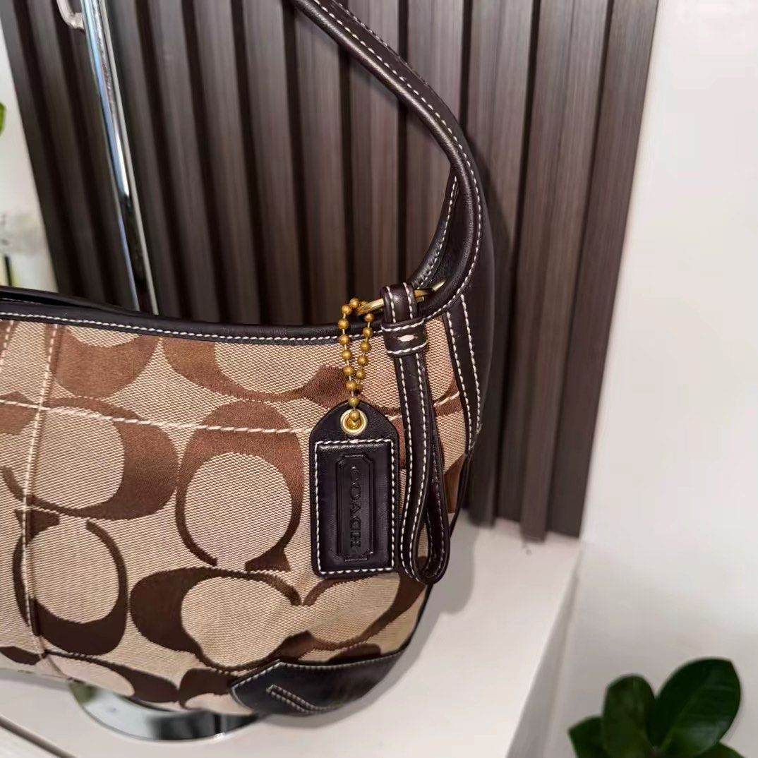 Coach Ergo (Category: Luxury Bags & Wallets) located in Los Banos. Submitted by vvvintiquecollectives (Listing ID 1447327177, Image 3). Description: - Classic Coach hobo bag - Signature monogram canvas with dark brown leather trim - Front pocket with gold-tone clasp - Top zipper closure - Timeless design for everyday use - Comes with Coach hang tag - Negotiable for sure buyers .