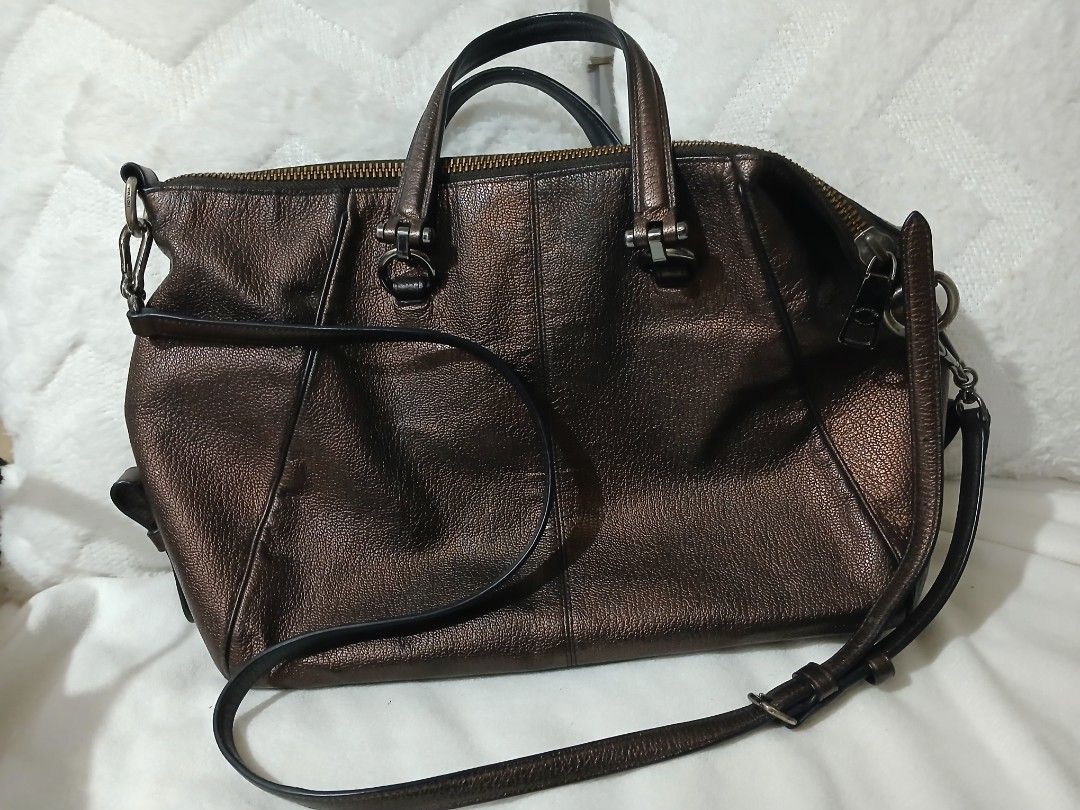 Coach Metallic Bronze Leather Satchel Handbag (Category: Luxury Bags & Wallets) located in Quezon City. Submitted by mapanak24 (Listing ID 1447336052, Image 2). Description: - Genuine leather Coach satchel bag - Cool metallic bronze color - Top handles and detachable crossbody strap - Multiple zippered pockets (front and top) - Spacious interior for essentials - Versatile for everyday use or nights out.