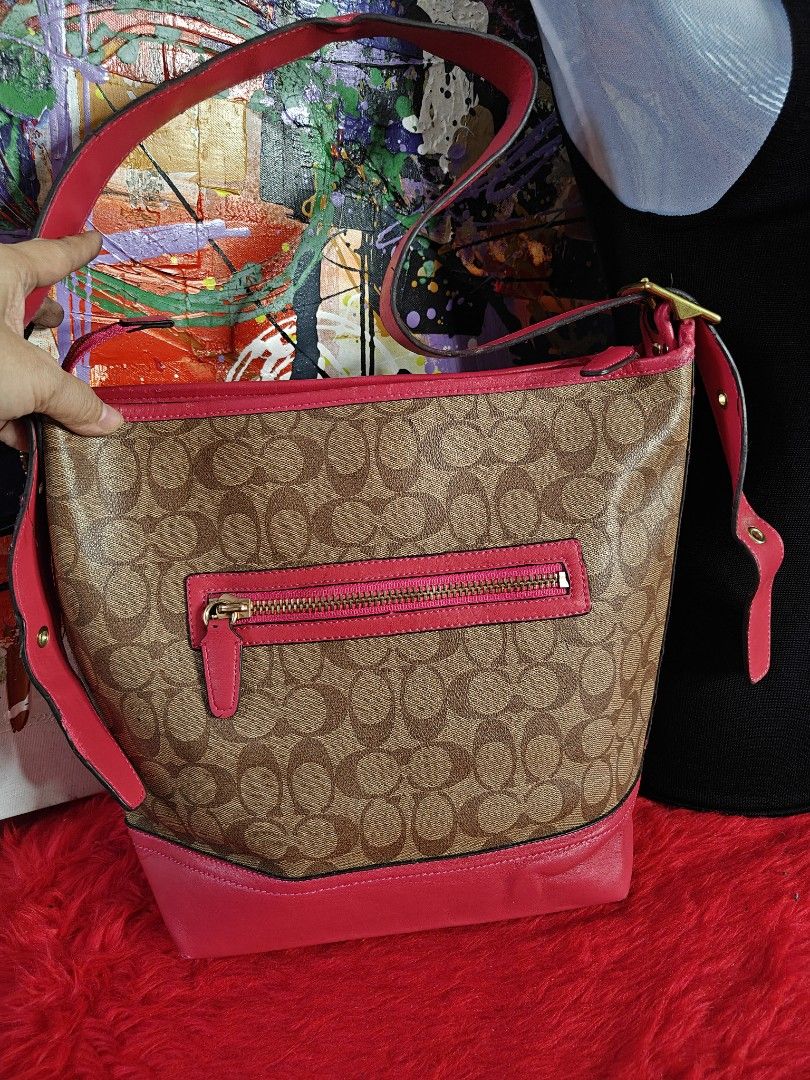 Coach Monogram Shoulder Bag with Pink Leather Trim (Category: Luxury Bags & Wallets) located in Las Pinas. Submitted by liezel49 (Listing ID 1447311028, Image 2). Description: - Classic Coach monogram shoulder bag - Color: Brown and tan signature pattern with pink leather trim and strap - Features a zippered pocket on the back - Gold hardware - Ideal for everyday use - Shows some signs of wear on the bottom corners see pics posted for bag prefere