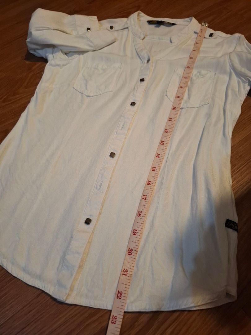 FREEGO Jeans Co. White Button-Up Shirt (Category: Shirts) located in Bacolod City. Submitted by gluisa97 (Listing ID 1447360969, Image 2). Description: - Brand: FREEGO Jeans Co. - Collar: Mandarin collar - Closure: Button-down front - Pockets: Two chest pockets with button closures - Sleeves: Roll-up sleeve tabs - Measurements: Approx. 15 inches (chest), 23 inches (length) - Occasion: Casual wear, Office Wear - Light & comfy fabric. Wrinkled lang