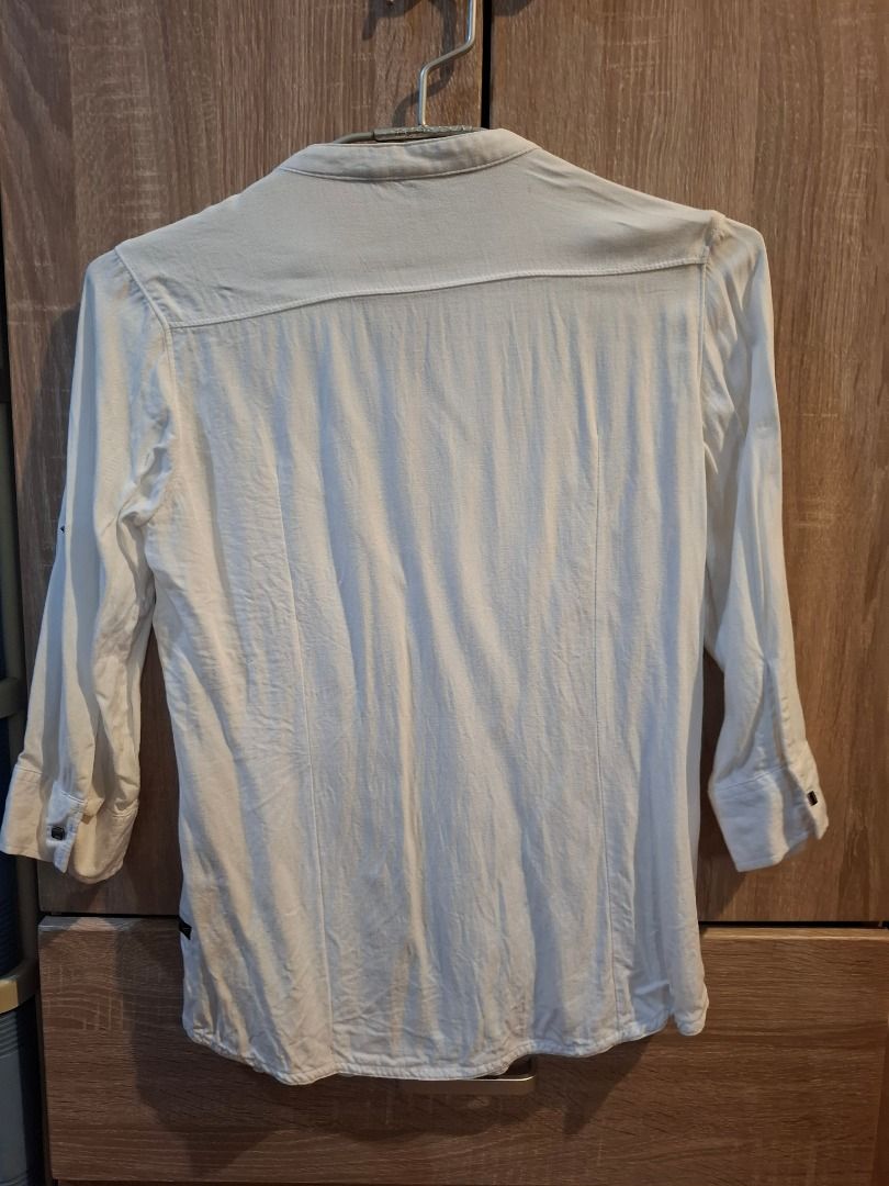 FREEGO Jeans Co. White Button-Up Shirt (Category: Shirts) located in Bacolod City. Submitted by gluisa97 (Listing ID 1447360969, Image 3). Description: - Brand: FREEGO Jeans Co. - Collar: Mandarin collar - Closure: Button-down front - Pockets: Two chest pockets with button closures - Sleeves: Roll-up sleeve tabs - Measurements: Approx. 15 inches (chest), 23 inches (length) - Occasion: Casual wear, Office Wear - Light & comfy fabric. Wrinkled lang