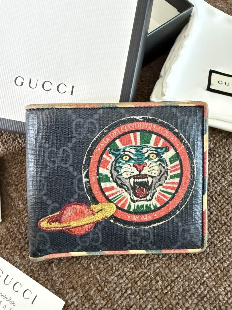 Gucci Tiger & Planet Bi-fold Wallet (Category: Luxury Bags & Wallets) located in Quezon City. Submitted by benta_sulit (Listing ID 1447373268, Image 2). Description: - Authentic Gucci bi-fold wallet - Iconic GG monogram canvas - Unique tiger and planet patch - Multiple card slots and bill compartments - Comes with original box, dust bag, and authenticity cards - Ideal for everyday use.