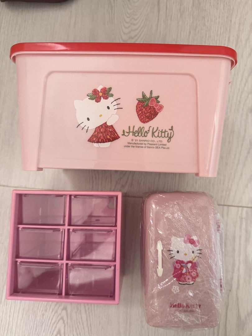 Hello Kitty Pink Storage Box, Organizer, and Mini Fridge (Category: Storage Boxes & Baskets) located in Cavite. Submitted by abiichiix (Listing ID 1447356628, Image 1). Description: Take All💞 - Set of 3 adorable Kitty storage items. - Includes a large pink storage box with a cute strawberry design. - Comes with a pink organizer featuring six convenient compartments. - Also includes a mini fridge-shaped container, still sealed in plastic wrap. - 