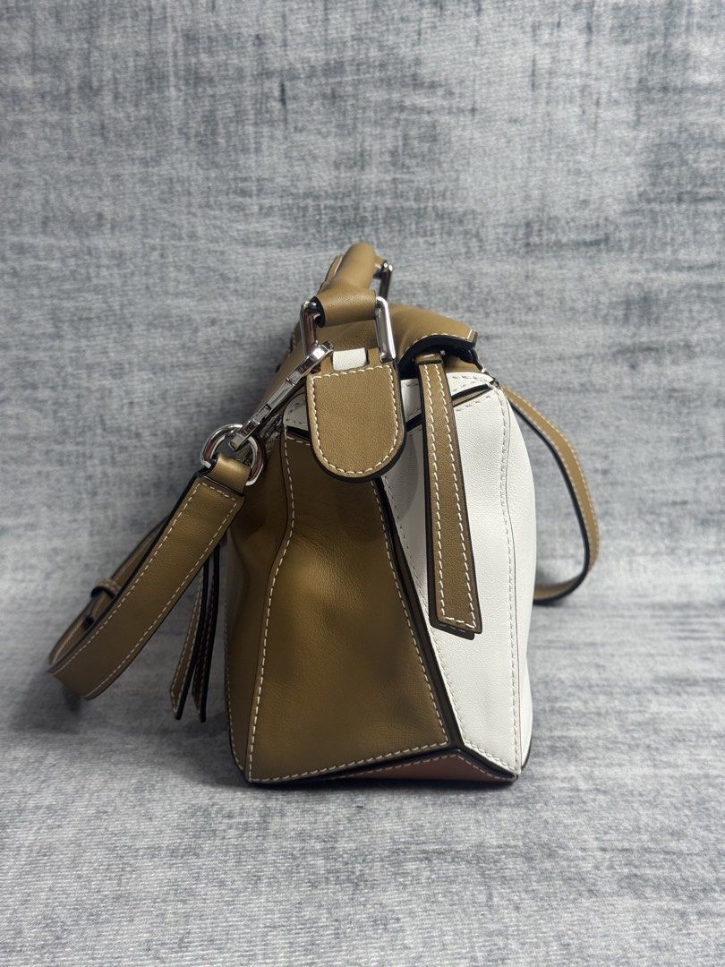 Loewe - Small Puzzle Bag (Category: Luxury Bags & Wallets) located in Manila. Submitted by members-only (Listing ID 1447417347, Image 3). Description: Loewe Small Puzzle Bag •Shoulder, crossbody, top handle or clutch carry •Removable shoulder strap •Zip closure with calfskin pull •Handy exterior zip back pocket •One interior pocket •Herringbone cotton canvas lining •Color: Ochre/Soft White •Material: 100% Leather Rating: 9/10 No issue to report (