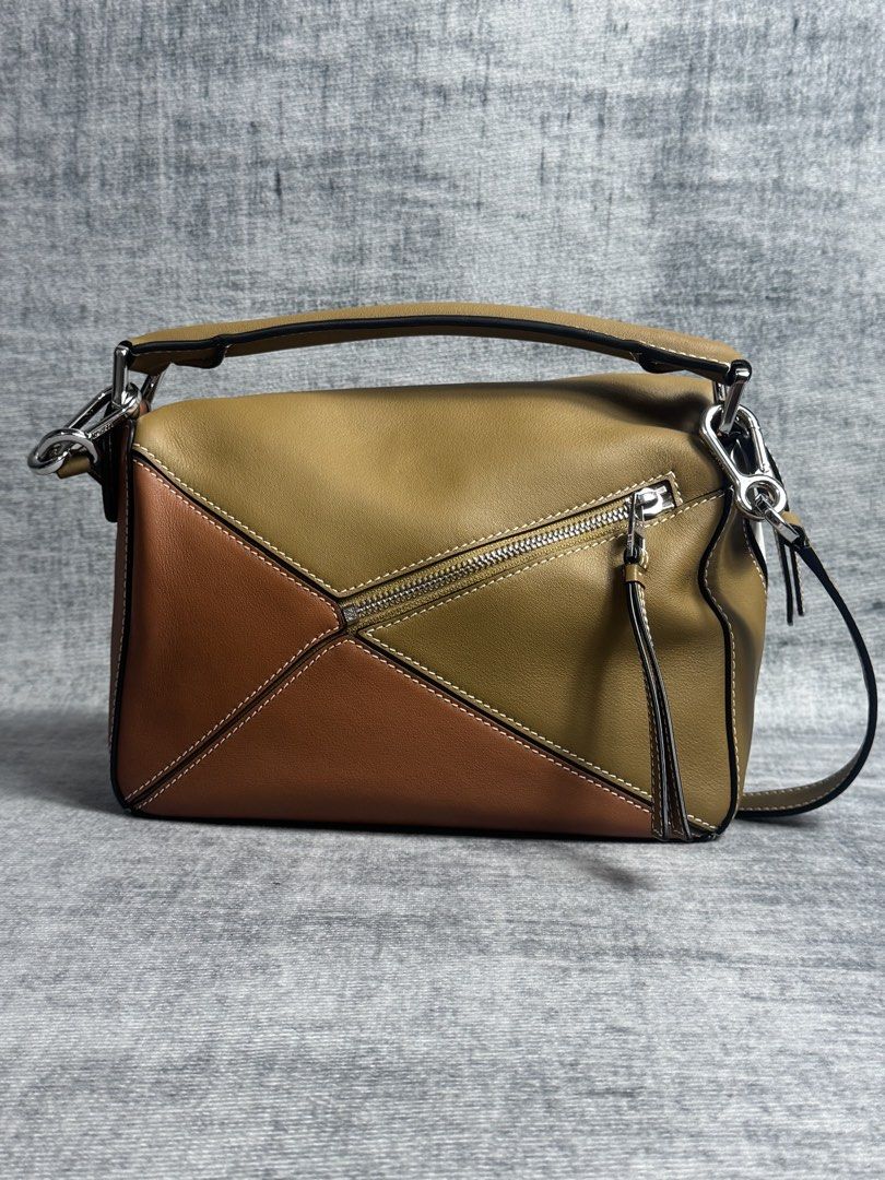 Loewe - Small Puzzle Bag (Category: Luxury Bags & Wallets) located in Manila. Submitted by members-only (Listing ID 1447417347, Image 2). Description: Loewe Small Puzzle Bag •Shoulder, crossbody, top handle or clutch carry •Removable shoulder strap •Zip closure with calfskin pull •Handy exterior zip back pocket •One interior pocket •Herringbone cotton canvas lining •Color: Ochre/Soft White •Material: 100% Leather Rating: 9/10 No issue to report (