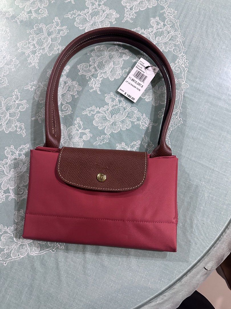 Longchamp Le Pliage Shoulder Bag (Category: Luxury Bags & Wallets) located in Bulacan. Submitted by memayeselfinday (Listing ID 1447468832, Image 2). Description: - Classic Longchamp Le Pliage shoulder bag - Small size - Lovely pinkish-red color - Brown leather handles and trim - Folds flat for easy storage - Great everyday bag.
