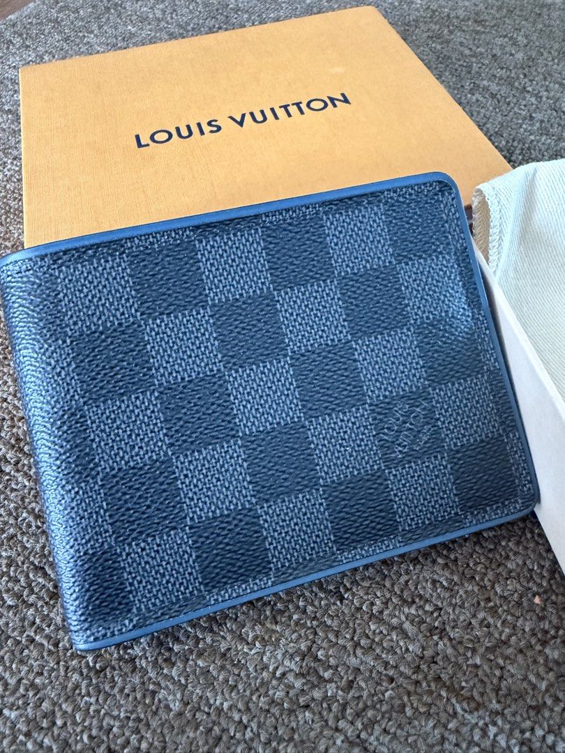 Louis Vuitton Damier Graphite Multiple Wallet (Category: Luxury Bags & Wallets) located in Quezon City. Submitted by benta_sulit (Listing ID 1447372339, Image 2). Description: - Authentic Louis Vuitton Wallet - Damier Graphite Canvas with Blue Leather Interior - Made in France - Includes Original Box, Dust Bag, and Authenticity Card - Multiple Card Slots and Bill Compartment - Ideal for Everyday Use.
