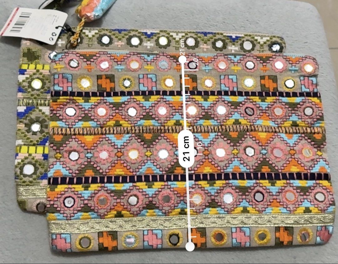 Mango Embroidered Clutch Bag with Mirror Details (Category: Clutches) located in San Pedro. Submitted by me-shops (Listing ID 1447341040, Image 3). Description: -Brand: Mango - Features vibrant, colorful embroidery - Embellished with mirror details - Convenient tassel zipper pull - Ideal for carrying your essentials - Dimensions: Approximately 31 cm x 21 cm - Perfect for a night out or as a bag organizer - Brand new with original tags.