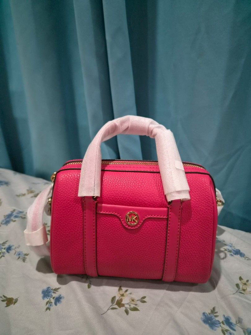 Michael Kors Pink Leather Barrel Handbag (Category: Luxury Bags & Wallets) located in Santo Tomas. Submitted by anacristin90526 (Listing ID 1447418958, Image 2). Description: - Authentic Michael Kors barrel handbag - Vibrant bright pink color - Genuine leather material - Elegant gold hardware - Secure zipper closure - Spacious interior with branded lining - Handle still has protective plastic wrap - Ideal for carrying your daily essentials.