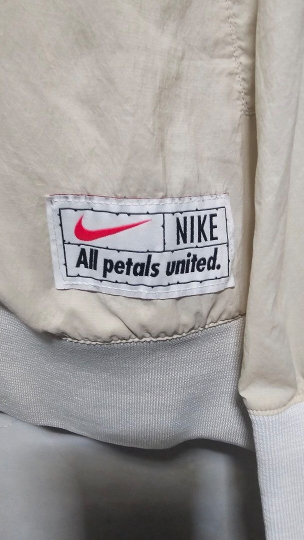 Nike Bomber Jacket "All Petals United" (Category: Coats, Jackets and Outerwear) located in Manila. Submitted by thrift_archive (Listing ID 1447428733, Image 2). Description: - Cream colored Nike bomber jacket - Small Nike logo on the front - Large Nike swoosh with 'Just Do It' text on the back - 'All Petals United' tag inside - Ribbed cuffs and hem - Zip-up front dimes 24w x 27L.