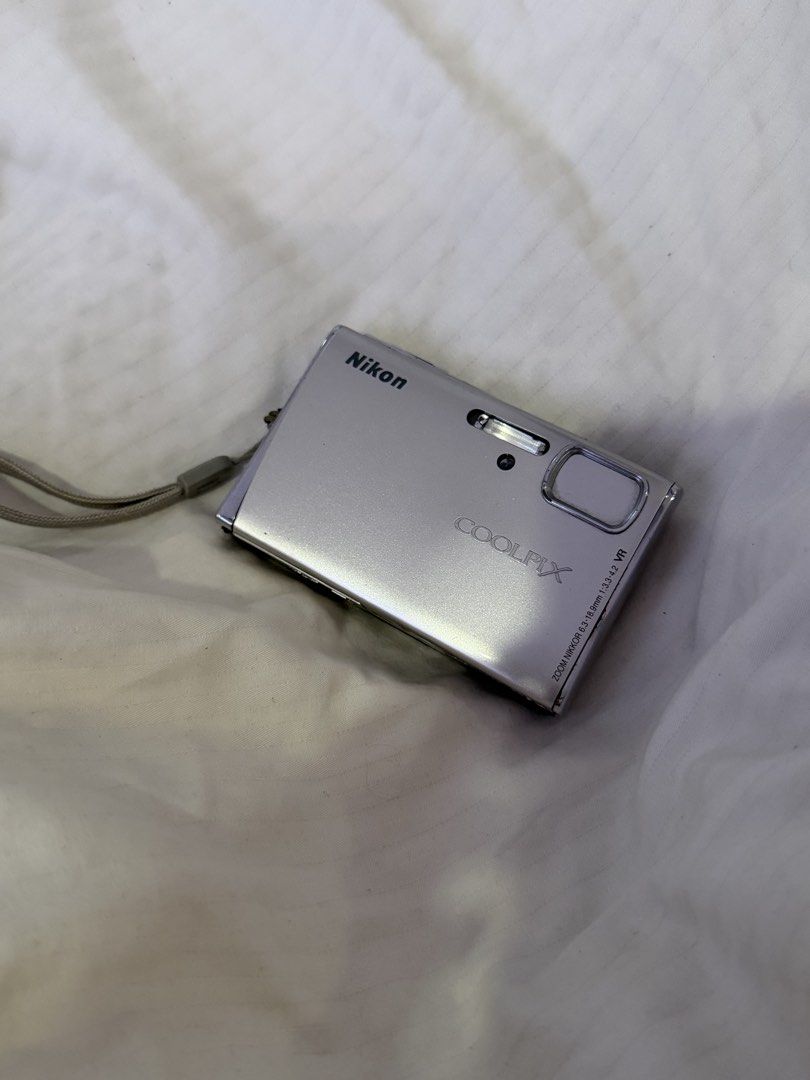 RUSH! Nikon Coolpix S51 Digital Camera (Category: Cameras) located in Las Pinas. Submitted by idontneedtheseanm (Listing ID 1447393691, Image 1). Description: - Silver Nikon Coolpix digital camera - Includes attached strap - Screen displays 'Lens error' message sometimes, but it also works - Sold as is - Ideal for parts or repair **could just need a new battery/lens cover repair.