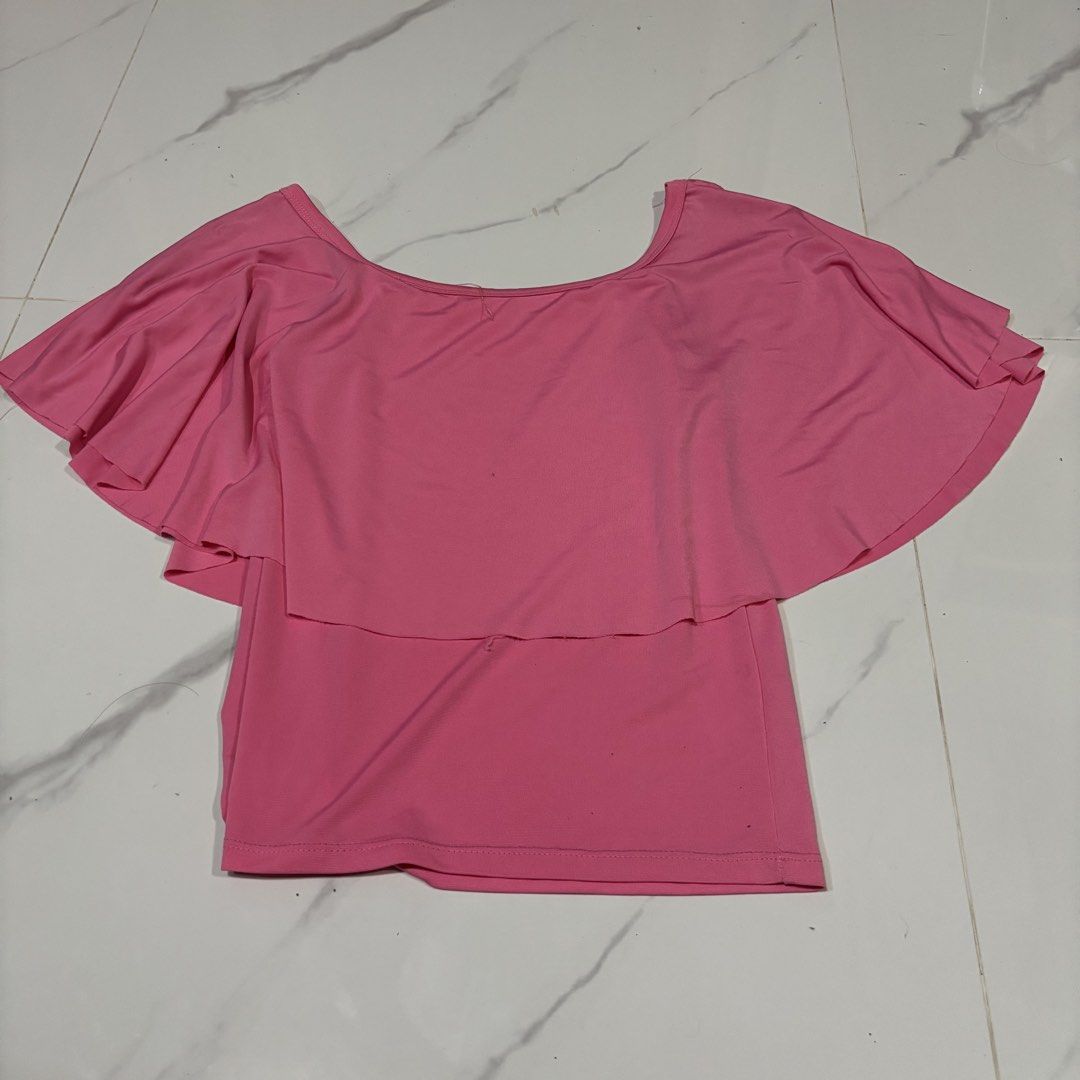 Pink Off-Shoulder Ruffle Top (Category: Blouses) located in Zaragoza. Submitted by starzoneph (Listing ID 1447410362, Image 1). Description: - Cute pink off-shoulder top - Layered ruffle detail across the chest - Flutter sleeves - Soft and stretchy fabric - Versatile for casual or evening wear - Easy to pair with jeans or skirts Measurements 📏 Length: 20 inches Width: 13 inches.