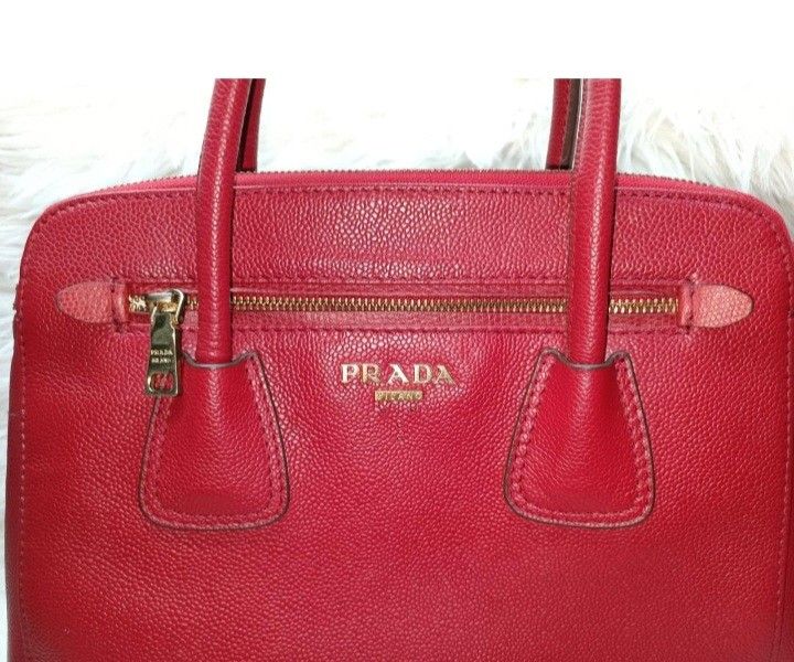 Prada Saffiano Leather Galleria Bag (red) (Category: Luxury Bags & Wallets) located in Baliuag. Submitted by mnldecluttter (Listing ID 1447466483, Image 2). Description: - Prada bag in vibrant red - Made from textured leather - Zip-top closure - Two top handles - Interior zip pocket - Central compartment - Gold-tone hardware- some fader - Versatile vintage for everyday or special occasions, genuine leather. - 4 hardware at the bottom with Prada c