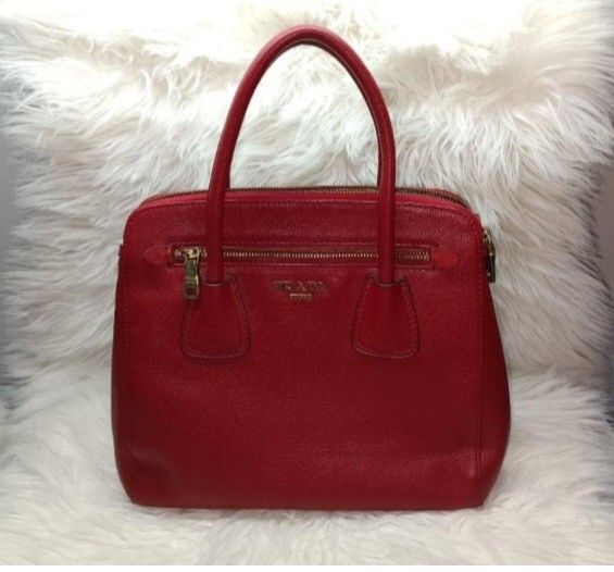 Prada Saffiano Leather Galleria Bag (red) (Category: Luxury Bags & Wallets) located in Baliuag. Submitted by mnldecluttter (Listing ID 1447466483, Image 1). Description: - Prada bag in vibrant red - Made from textured leather - Zip-top closure - Two top handles - Interior zip pocket - Central compartment - Gold-tone hardware- some fader - Versatile vintage for everyday or special occasions, genuine leather. - 4 hardware at the bottom with Prada c