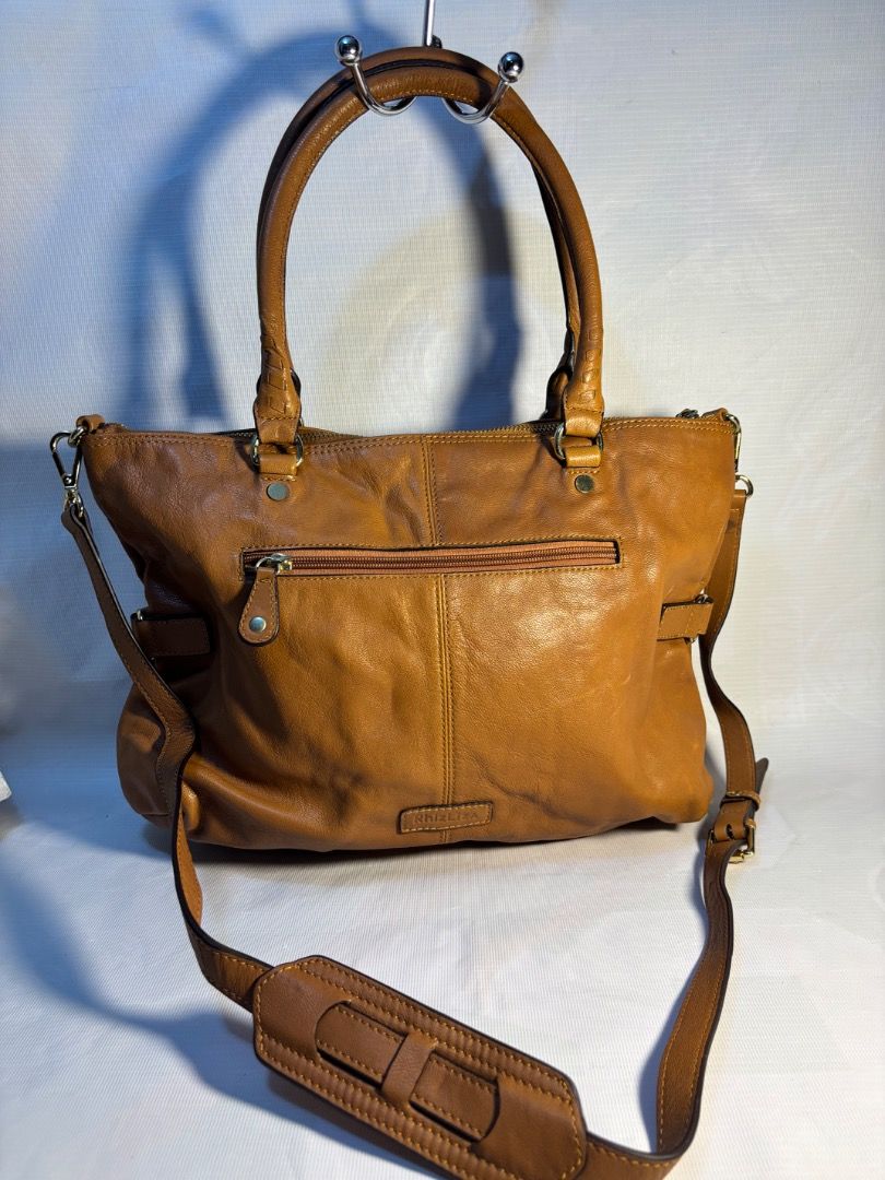 Rhizliza Brown Leather Shoulder Bag (Category: Shoulder Bags) located in Davao. Submitted by eladon27 (Listing ID 1447449098, Image 3). Description: - Brown leather shoulder bag from Rhizliza - Main compartment with internal pockets and a zip pocket - Top handles and a detachable shoulder strap - Elegant gold hardware details - Ample space for your daily essentials -2 way with sling -clean interior -no rubs on at the bottom.