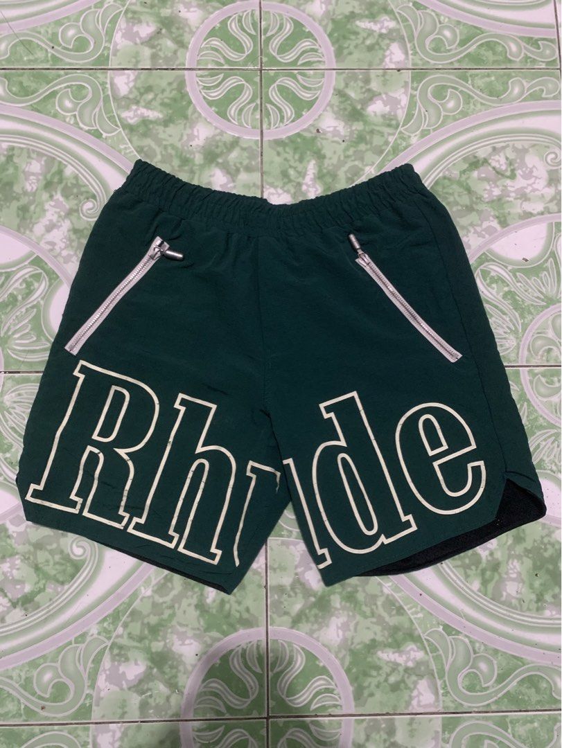 Rhude Green Shorts with White Logo (Category: Shorts) located in Manila. Submitted by haven_thrift (Listing ID 1447446609, Image 1). Description: - Authentic Rhude green shorts - White Rhude logo on both legs - Front zippered pockets for secure storage - Adjustable drawstring waist for a comfortable fit - Built-in mesh lining - Ideal for everyday casual wear or athletic activities.