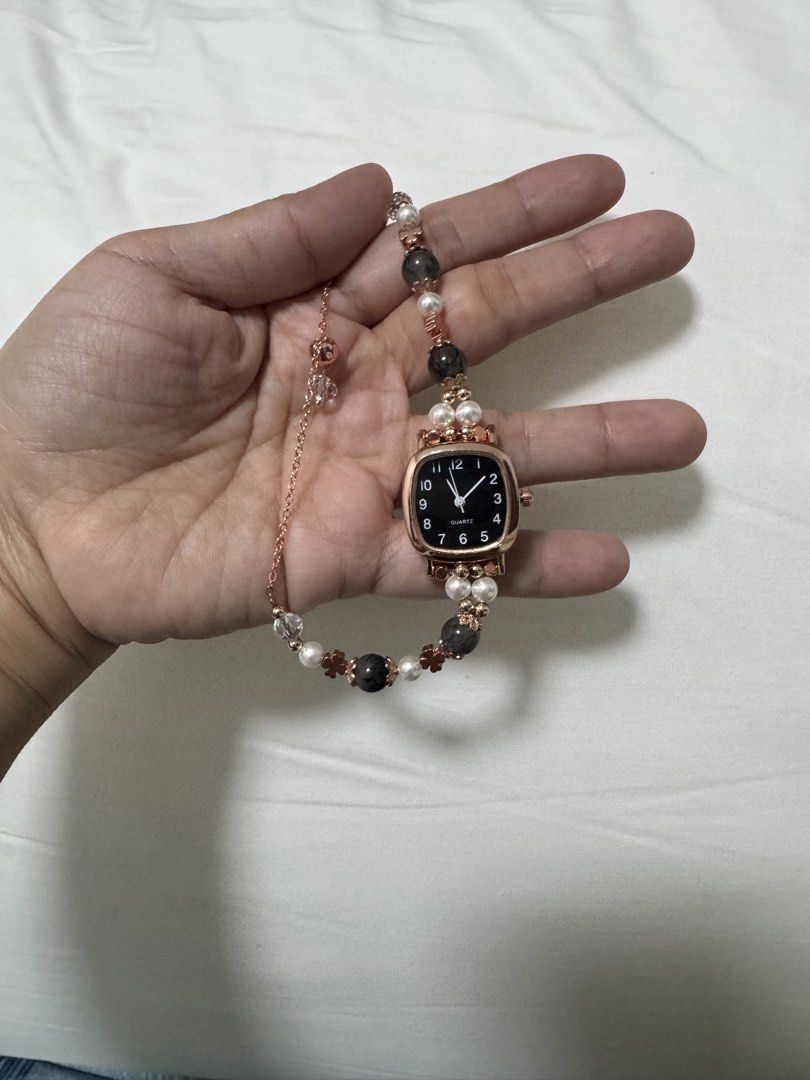 Rose Gold Quartz Watch with Beaded Bracelet (Category: Women's Watches) located in Guagua. Submitted by dixie_1028 (Listing ID 1447310384, Image 3). Description: - Unique square face watch - Black dial with rose gold casing - Bracelet with beads, pearls, and flower charms - Quartz movement - Perfect accessory for a distinctive look.