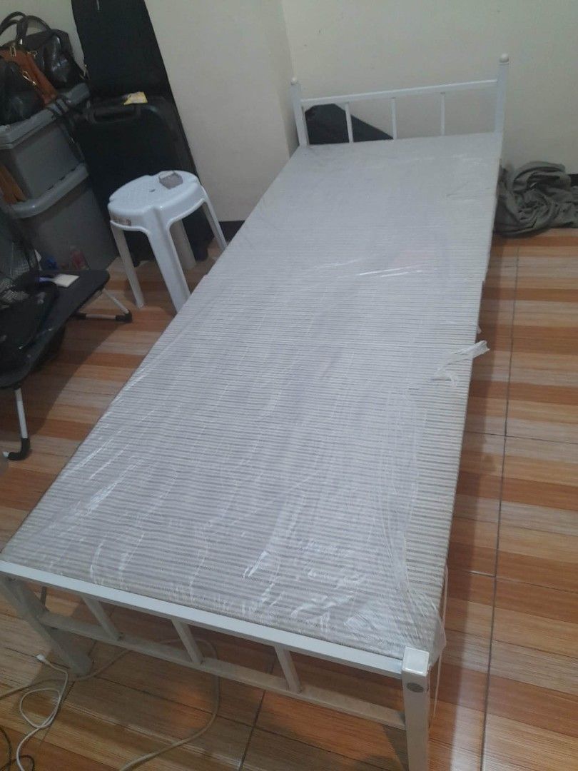 Single Bed Frame with Blue Camo Mattress (Category: Bed Frames & Mattresses) located in Manila. Submitted by dayanghira00486 (Listing ID 1447424813, Image 1). Description: - Single bed frame - White metal construction - Includes comfortable mattress with blue camouflage pattern -Size 30cm wide x 74cm length -Mattress covered with a fitted sheet - Ideal for small rooms or guest bedrooms - Easy to assemble, foldable in half.