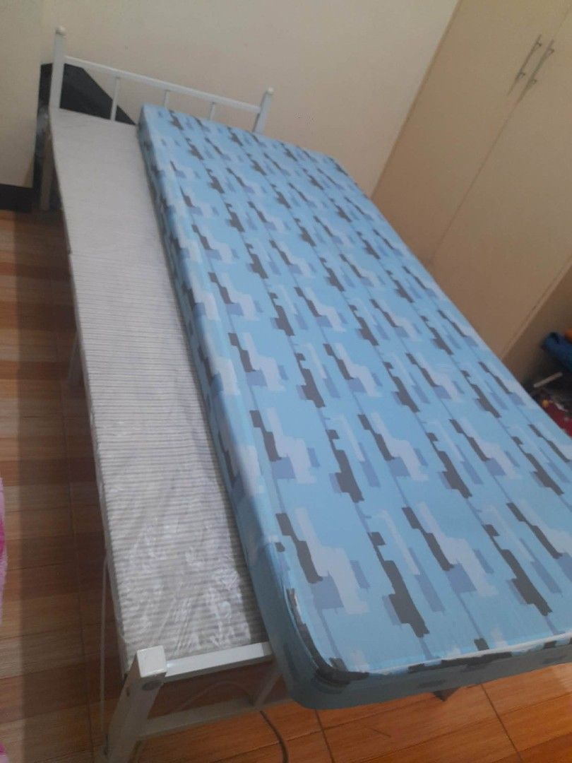 Single Bed Frame with Blue Camo Mattress (Category: Bed Frames & Mattresses) located in Manila. Submitted by dayanghira00486 (Listing ID 1447424813, Image 3). Description: - Single bed frame - White metal construction - Includes comfortable mattress with blue camouflage pattern -Size 30cm wide x 74cm length -Mattress covered with a fitted sheet - Ideal for small rooms or guest bedrooms - Easy to assemble, foldable in half.