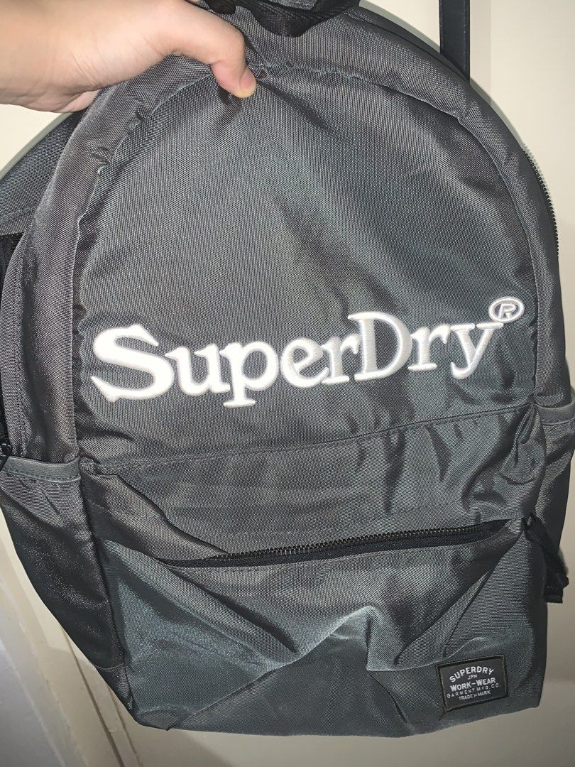 Superdry Grey Backpack Original (Category: Backpacks) located in Manila. Submitted by dsn_md (Listing ID 1447383390, Image 2). Description: Guaranteed Grey Superdry backpack Money back if proven fake PLEASE READ Issue: natambak lang so may onting dumi sa superdry na stitch sa harap. Medyo tricky din yung zipper ng bag pero parang factory defect nya talaga na naiipit sa cover lining. No other issues aside from normal usage. - Front zip pocket for 