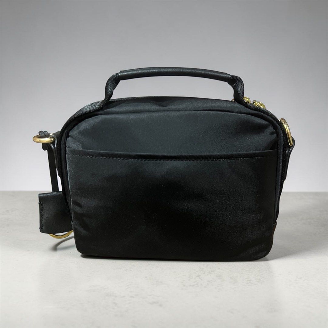 Tumi Black Nylon Satchel Bag with Gold Hardware (Category: Luxury Bags & Wallets) located in Makati City. Submitted by djcheng (Listing ID 1447373294, Image 2). Description: - Authentic Black Tumi crossbody Bag - Crafted from durable nylon with elegant leather accents - Features multiple secure zippered compartments - Includes a detachable crossbody strap for versatile carrying - Stylish gold hardware details - Ideal for everyday use and travel n