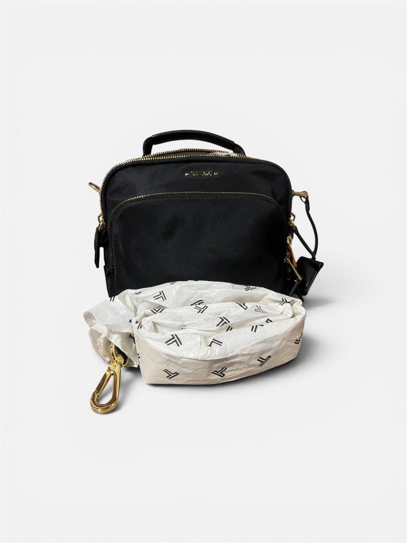 Tumi Black Nylon Satchel Bag with Gold Hardware (Category: Luxury Bags & Wallets) located in Makati City. Submitted by djcheng (Listing ID 1447373294, Image 3). Description: - Authentic Black Tumi crossbody Bag - Crafted from durable nylon with elegant leather accents - Features multiple secure zippered compartments - Includes a detachable crossbody strap for versatile carrying - Stylish gold hardware details - Ideal for everyday use and travel n