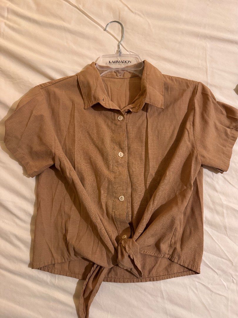 Beige Button Up Tie Front Polo Shirt Linen Blend (Category: Shirts) located in Quezon City. Submitted by ianne.declutter (Listing ID 1452832372, Image 1). Description: - Light brown short-sleeve button-up shirt - Collared neckline - Tie-front detail at the hem - Ideal for casual outfits.