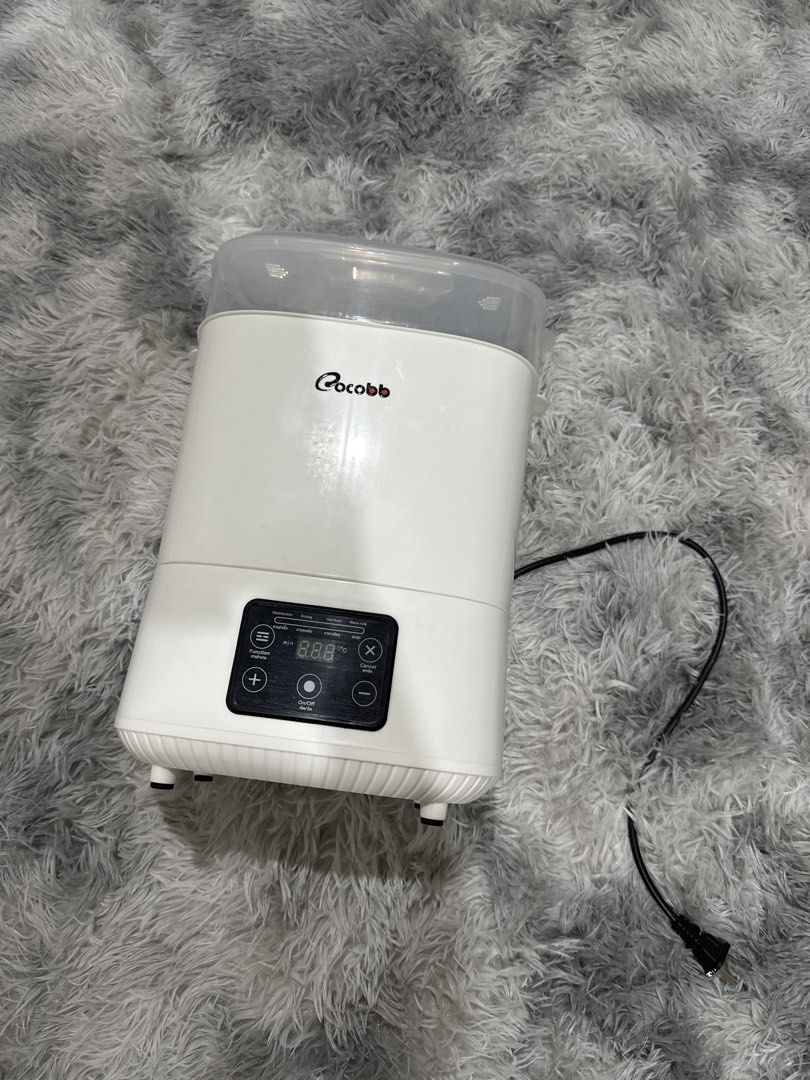 Cocobb Bottle Sterilizer and Dryer (Category: Breastfeeding & Bottle Feeding) located in Caloocan City. Submitted by sebaesic (Listing ID 1452759674, Image 1). Description: - White Cocobb bottle sterilizer - Functions: Sterilize, Dry, Warm milk - Digital display shows time and temperature - Includes: Main unit, inner rack, lid - Perfect for keeping baby bottles clean and ready.