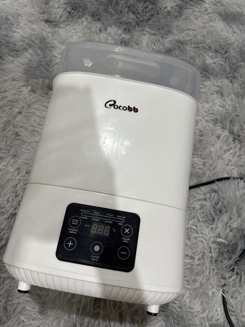 Cocobb Bottle Sterilizer and Dryer (Category: Breastfeeding & Bottle Feeding) located in Caloocan City. Submitted by sebaesic (Listing ID 1452759674, Image 2). Description: - White Cocobb bottle sterilizer - Functions: Sterilize, Dry, Warm milk - Digital display shows time and temperature - Includes: Main unit, inner rack, lid - Perfect for keeping baby bottles clean and ready.
