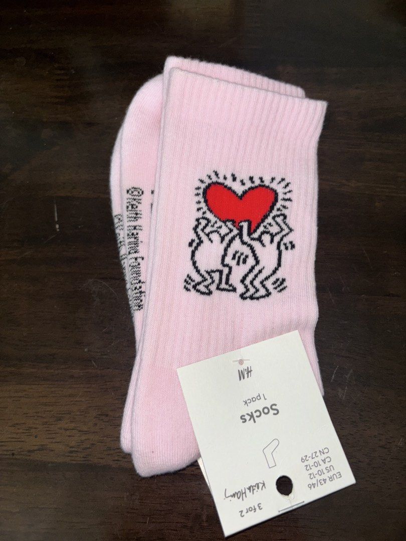 H&M x Keith Haring Pink Socks (Category: Socks & Tights) located in Caloocan City. Submitted by shopmyclosetttttt (Listing ID 1452721923, Image 1). Description: - Eye-catching pink socks with iconic Keith Haring artwork. - Features the famous heart design and signature figures. - Includes the official Keith Haring Foundation logo. - Size: EUR 43/46 (US 10-12, CN 27-29). - Ideal for Keith Haring enthusiasts and anyone seeking unique, artistic sock