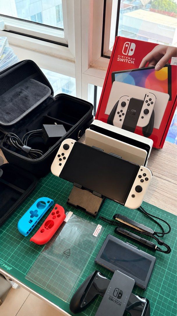 Nintendo Switch OLED Model White with Accessories (Category: Nintendo) located in Quezon City. Submitted by EMSLORENZO (Listing ID 1452764545, Image 1). Description: - Nintendo Switch OLED Model (White) - Includes original dock and Joy-Cons - All necessary charging cables included - Comes with Nacon protective travel case XL - Extra Joy-Con grips for enhanced comfort - Pre-applied screen protector for immediate use - Original packaging included -