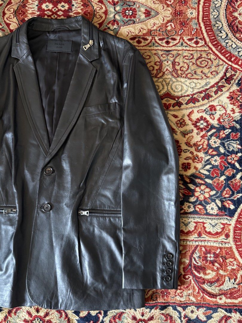 Prada - Tactical - Lambskin Leather Blazer (Category: Luxury Apparel) located in San Fernando. Submitted by larchivefeminine (Listing ID 1452716814, Image 3). Description: Prada - Tactical - Lambskin Leather Blazer Collared Zipper / Pockets Fresh Leather Size on tag : 52 Dimensions Width : 21.5in Length : 27in Sleeve : 25in Shoulder : 18in Condition : 9/10 No major flaws Soft Leather Made in : China Material : Lambskin Zipper : Opti Color : Black