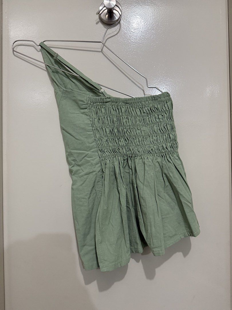 Sage Green One Shoulder Smocked Crop Top (Category: Sleeveless) located in Pasig City. Submitted by rchsh (Listing ID 1452825075, Image 2). Description: - Sage green one-shoulder top - Smocked bodice for a comfortable fit - Ruffled hem for a feminine touch - Lightweight fabric, ideal for summer weather - Versatile: pairs easily with shorts or skirts - Effortlessly cute and breezy style Never been used.