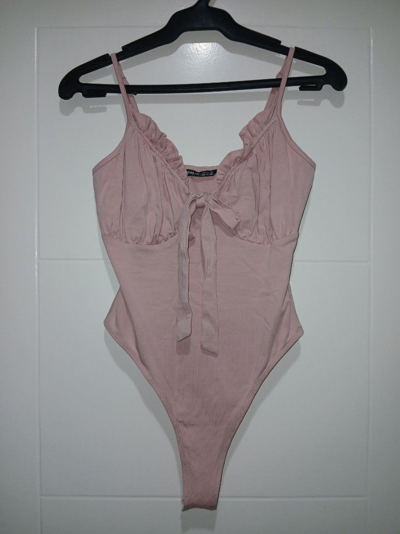 SHEIN Pink Bustier Ruched Tie Front Bodysuit (Category: Others Tops) located in Paranaque City. Submitted by thepennydreadful (Listing ID 1452745954, Image 1). Description: stretch. never worn. just stored - Pink ribbed bodysuit from SHEIN - Ruched detail on bust with tie front - Adjustable spaghetti straps - Super cute and comfy - Great for layering or wearing on its own.