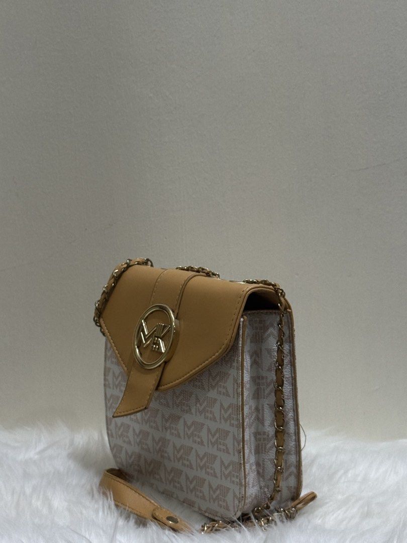 Tan & Monogram Canvas Flap Chain Crossbody Sling Bag (Category: Cross-body Bags) located in Quezon City. Submitted by clazzystudio (Listing ID 1452808932, Image 2). Description: Selling this chic tan crossbody bag featuring a classic monogram printed canvas body, smooth tan faux leather flap, and a circular gold-tone MK logo emblem. It features a sleek vertical envelope design and a long gold chain strap woven with leather. Perfect for adding an 