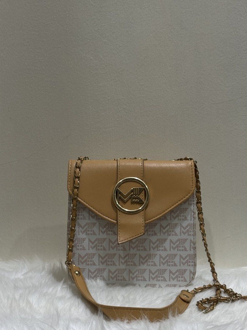 Tan & Monogram Canvas Flap Chain Crossbody Sling Bag (Category: Cross-body Bags) located in Quezon City. Submitted by clazzystudio (Listing ID 1452808932, Image 1). Description: Selling this chic tan crossbody bag featuring a classic monogram printed canvas body, smooth tan faux leather flap, and a circular gold-tone MK logo emblem. It features a sleek vertical envelope design and a long gold chain strap woven with leather. Perfect for adding an 