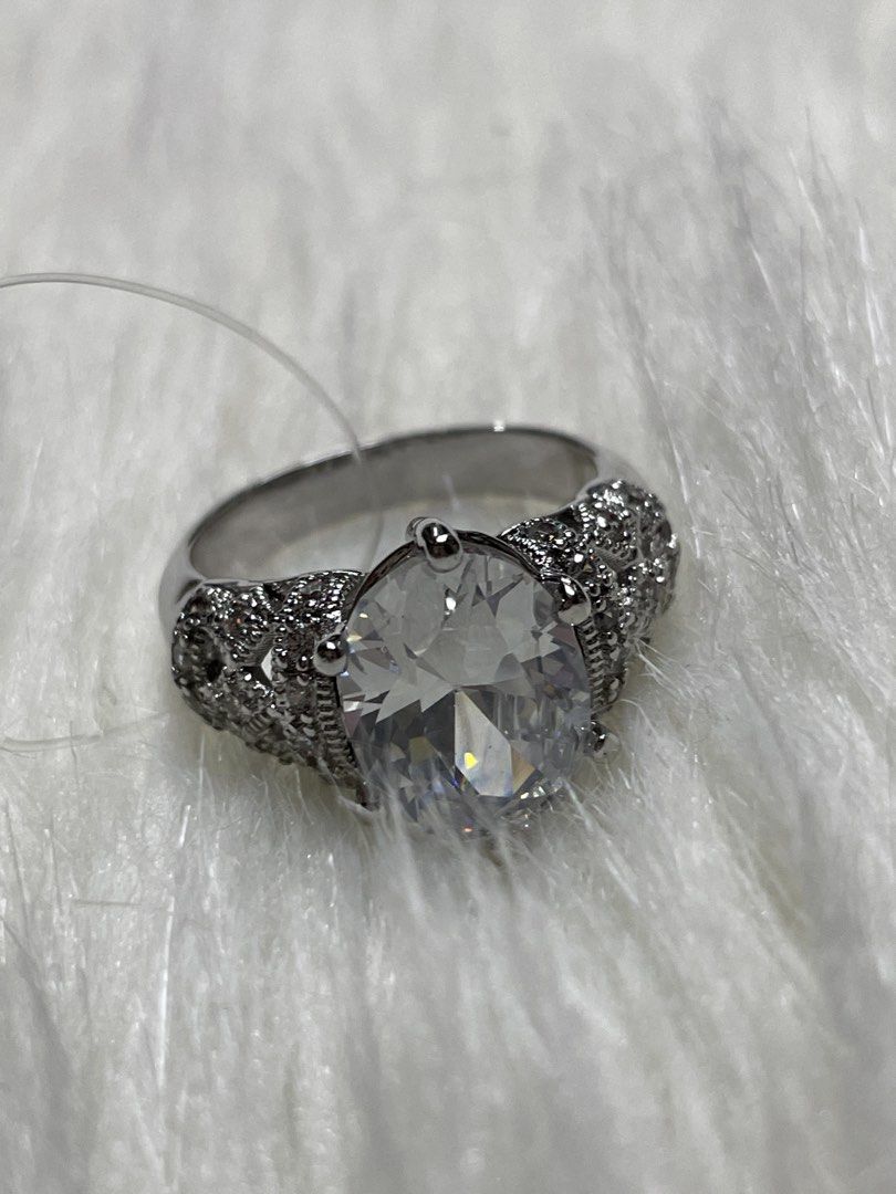 Sparkling Silver tone Ring with Large Clear Stone size 7-8 (Category: Rings) located in San Juan City. Submitted by redrosierose (Listing ID 1452832902, Image 1). Description: - Silver-toned statement ring size 8-9 Preloved Fashion Ring (Not Real Diamond) - Features a large, clear faceted stone - Intricate band detailing with smaller stones - Shiny and eye-catching design - Perfect for dressing up any outfit / parties -NOT REAL SILVER Shipping Ca