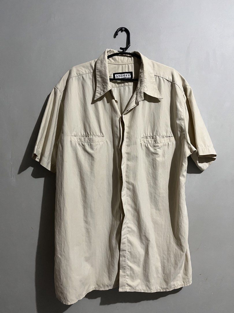 Stones Collection Short Sleeve Button Up Shirt (Category: Tshirts & Polo Shirts ) located in Cavite. Submitted by nathanluis (Listing ID 1452791882, Image 1). Description: - Lightweight short sleeve shirt from Stones Collection. - Classic button-up style. - Two chest pockets. - Neutral beige color, versatile for pairing. - Ideal for casual wear or layering. Issue: missing button on lower middle, replaceable.