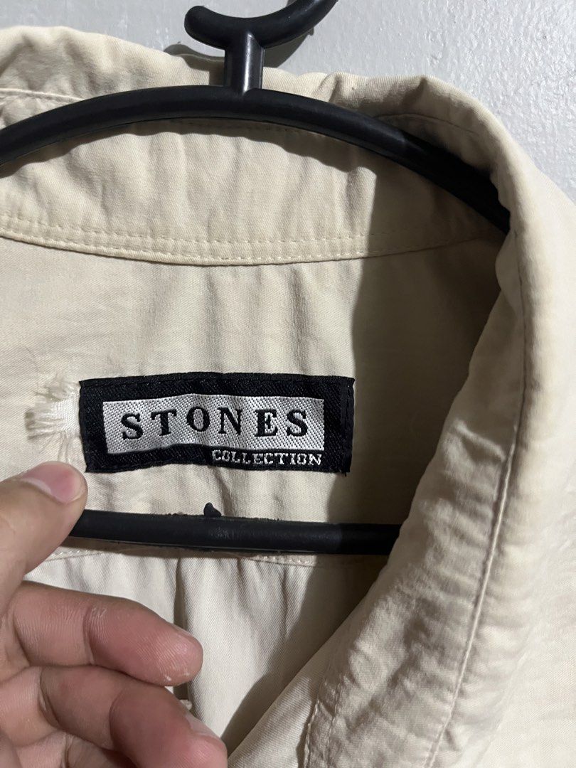 Stones Collection Short Sleeve Button Up Shirt (Category: Tshirts & Polo Shirts ) located in Cavite. Submitted by nathanluis (Listing ID 1452791882, Image 3). Description: - Lightweight short sleeve shirt from Stones Collection. - Classic button-up style. - Two chest pockets. - Neutral beige color, versatile for pairing. - Ideal for casual wear or layering. Issue: missing button on lower middle, replaceable.