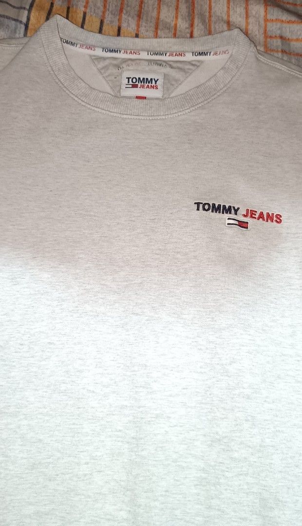 Tommy Jeans Grey Crewneck Sweatshirt (Category: Coats, Jackets and Outerwear) located in Caloocan City. Submitted by ThriftMoYanEh (Listing ID 1452766611, Image 3). Description: AUTHENTIC TOMMY JEANS STRETCHY CREWNECK PULLOVER EXCELLENT CONDITION MAKAPAL ANG TELA DIMENSION: 22x27 COLOR RATE 9.5/10 LIGHT GRAY COLOR SIZE LARGE ABOUT: - Grey Tommy Jeans crewneck sweatshirt - Small embroidered logo on the chest - Ribbed cuffs and hem for a classic fi