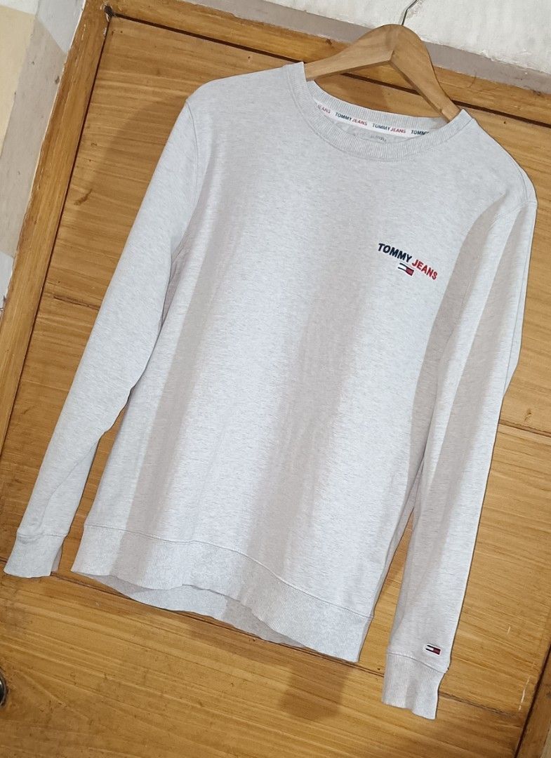 Tommy Jeans Grey Crewneck Sweatshirt (Category: Coats, Jackets and Outerwear) located in Caloocan City. Submitted by ThriftMoYanEh (Listing ID 1452766611, Image 2). Description: AUTHENTIC TOMMY JEANS STRETCHY CREWNECK PULLOVER EXCELLENT CONDITION MAKAPAL ANG TELA DIMENSION: 22x27 COLOR RATE 9.5/10 LIGHT GRAY COLOR SIZE LARGE ABOUT: - Grey Tommy Jeans crewneck sweatshirt - Small embroidered logo on the chest - Ribbed cuffs and hem for a classic fi