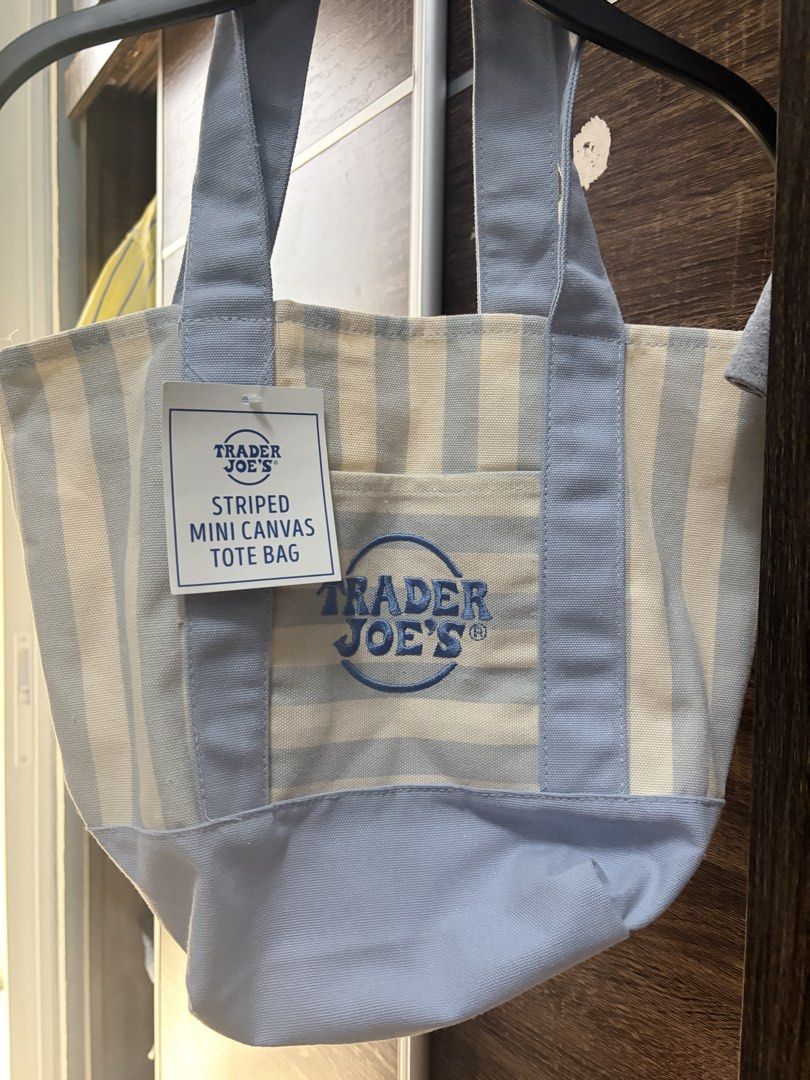 Trader Joe's Striped Mini Canvas Tote Bag (Category: Tote Bags) located in Bulacan. Submitted by fayyeeevorite (Listing ID 1452719919, Image 1). Description: - Cute mini tote bag from Trader Joe's - Features light blue and cream stripes - Embroidered Trader Joe's logo on front pocket - Ideal for quick errands or carrying essentials - Made of durable canvas material.